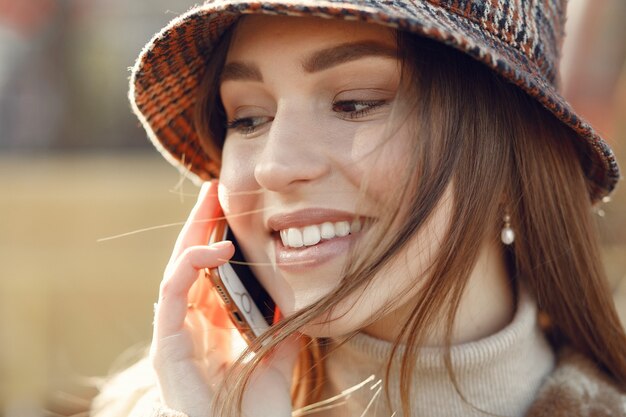 Dziewczyna spaceru w mieście wiosny i przy użyciu telefonu