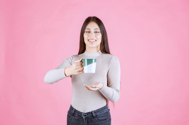 Dziewczyna trzyma kubek kawy biały kolor zielony i pozytywne samopoczucie