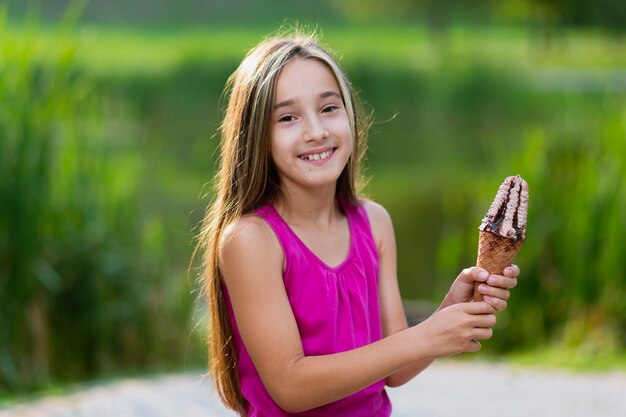 Dziewczyna trzyma lody czekoladowe i syropowe