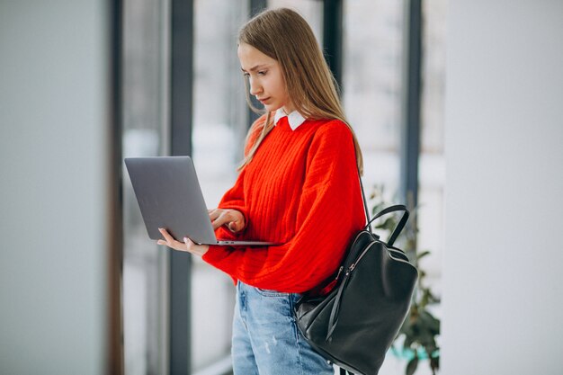 Dziewczyna uczeń z laptop pozycją okno w korytarzu