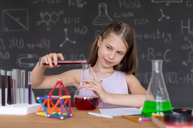 Dziewczyna uczy się więcej o chemii w klasie