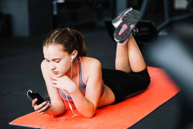 Dziewczyna używa telefon przy gym