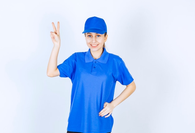 Dziewczyna w niebieskim mundurze przedstawiający znak przyjemności.
