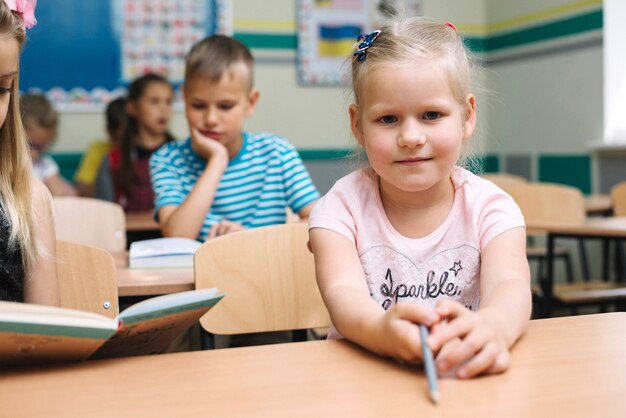 Dziewczyna w różowej koszuli siedzi przy stole