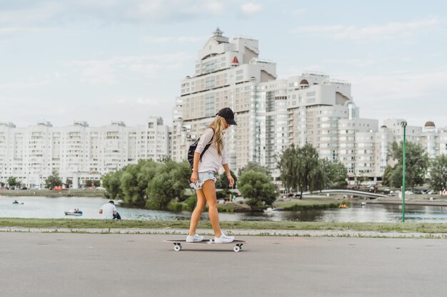 dziewczyna z długimi włosami łyżwy na deskorolce. ulica, aktywny sport