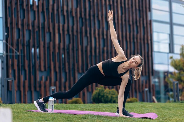 Dziewczyna z kucykiem robi fitness, ćwicząc na świeżym powietrzu