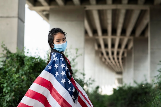 Dziewczyna z maską i amerykańską flagą średni strzał