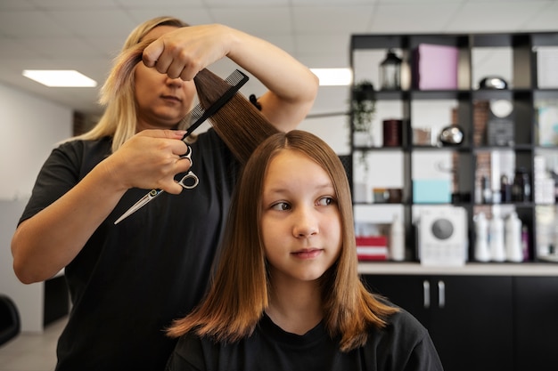 Bezpłatne zdjęcie dziewczyna z widokiem z przodu robi fryzurę w salonie