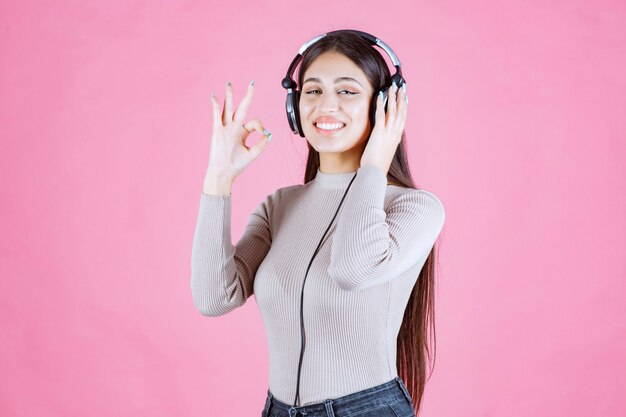 Dziewczyna ze słuchawkami, słuchanie muzyki i pokazywanie jej radości