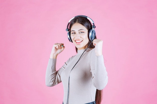 Dziewczyna ze słuchawkami, słuchanie muzyki i uczucie szczęścia