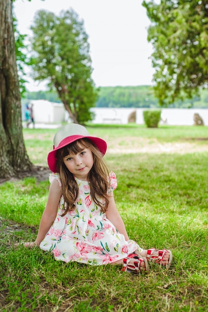 Dziewczynka siedzi na trawniku w parku