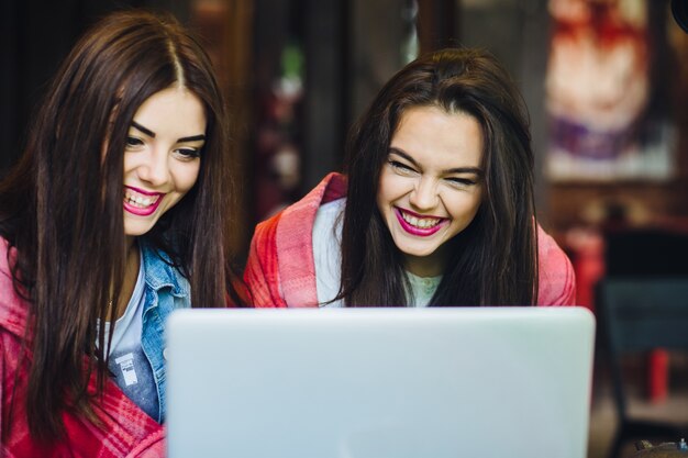 Dziewczynki śmiechu podczas wyglądają w laptopie