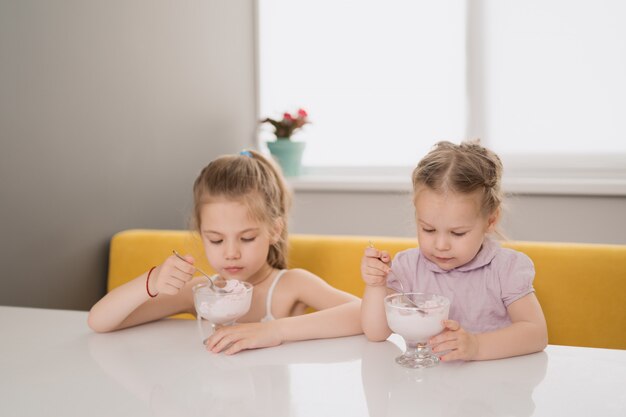 Dziewczyny jedzą lody przy stole