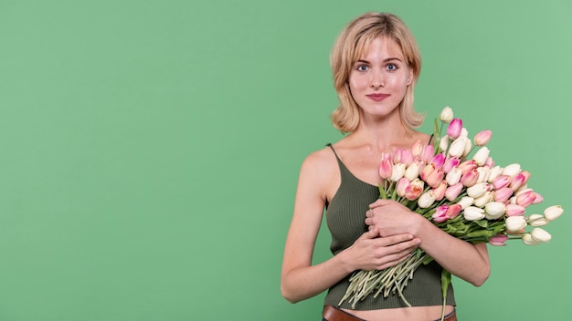 Bezpłatne zdjęcie dziewczyny mienia kwiaty i patrzeć fotografa