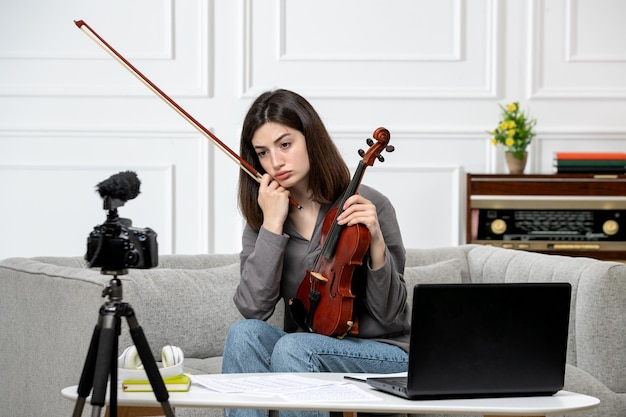 E-learning zdalnie daje lekcje gry na skrzypcach w domu młoda urocza piękna dziewczyna nagrywa wideo