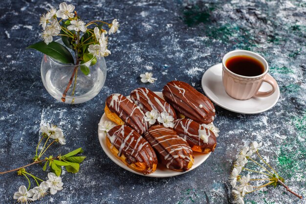 Eklery lub profiteroles z czarną czekoladą i białą czekoladą z kremem w środku, tradycyjny francuski deser.