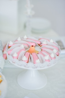 Eklery pokryte różową glazurą podawane na okrągłym białym talerzu