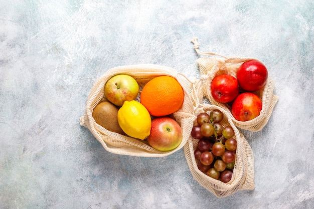 Ekologiczne, proste beżowe bawełniane torby na zakupy do kupowania owoców i warzyw z letnimi owocami.