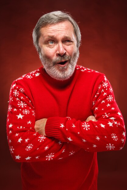 Ekspresyjny mężczyzna w czerwonym swetrze świątecznym