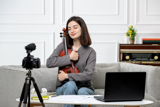 Elearning zdalnie w domu daje lekcje skrzypiec młoda urocza piękna dziewczyna bardzo szczęśliwa