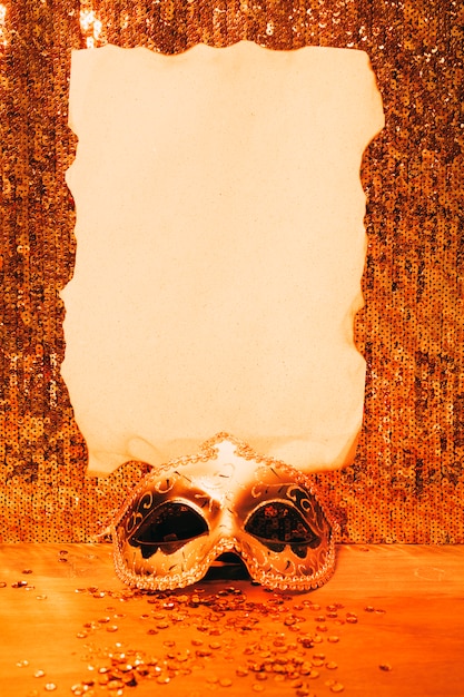 Bezpłatne zdjęcie elegancka karnawałowa maska z wypalonym papierem na błyszczącej cekinowej tkaninie