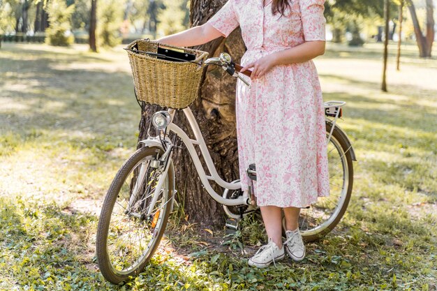 Elegancka młoda kobieta pozuje z rowerem