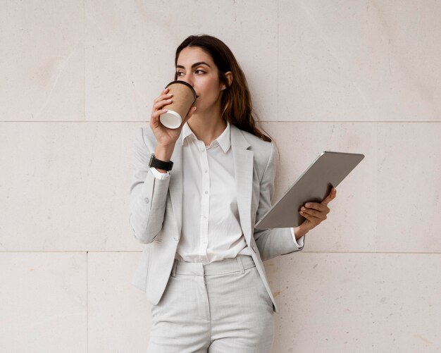 Elegancki bizneswoman kawę trzymając tabletkę