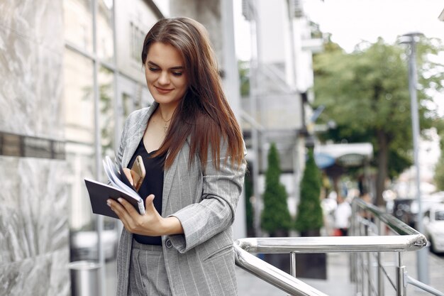 Elegancki bizneswoman pracuje w mieście i używa notatnika