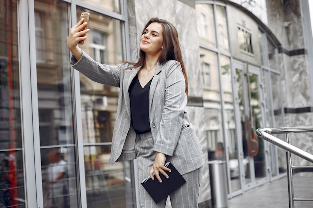 Elegancki bizneswoman pracuje w mieście i używa notatnika