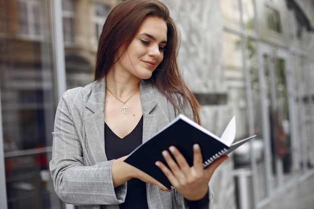 Elegancki bizneswoman pracuje w mieście i używa notatnika