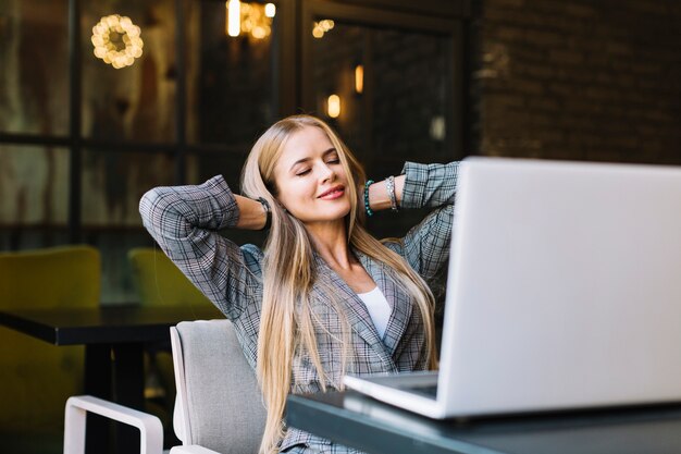 Elegancki bizneswoman z laptopem w wygodnym sklep z kawą