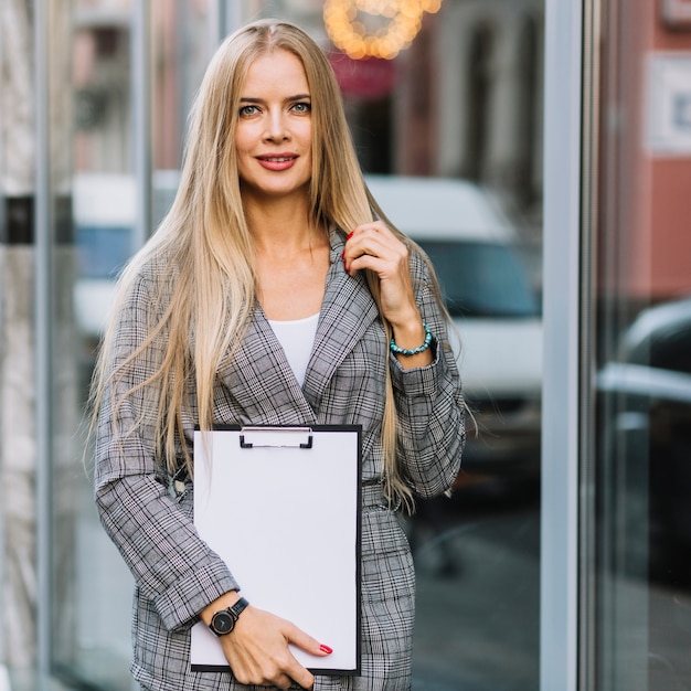 Elegancki bizneswoman z schowkiem w mieście