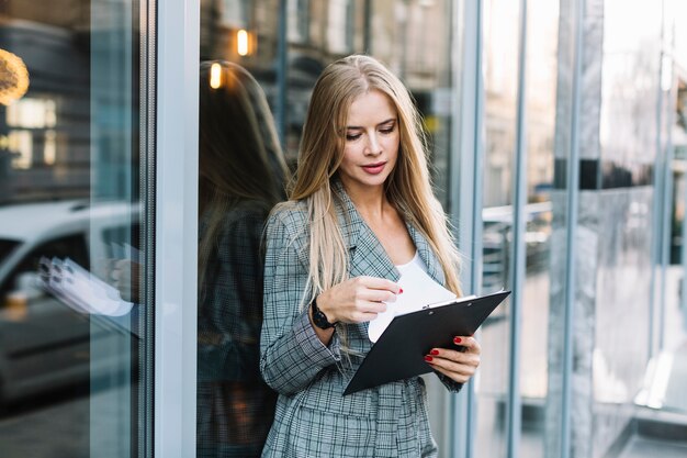 Elegancki bizneswoman z schowkiem w mieście