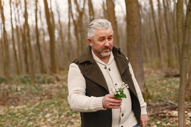 Bezpłatne zdjęcie elegancki dorosły mężczyzna w lesie wiosną