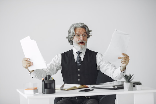 Bezpłatne zdjęcie elegancki mężczyzna w biurze. biznesmen w białej koszuli. mężczyzna pracuje z dokumentami.