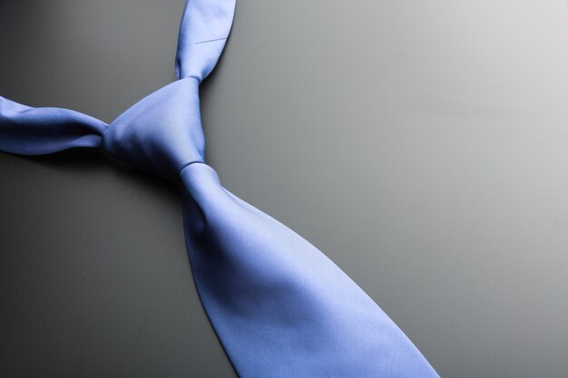 Elegancki niebieski krawat na czarnym tle zbliżenia