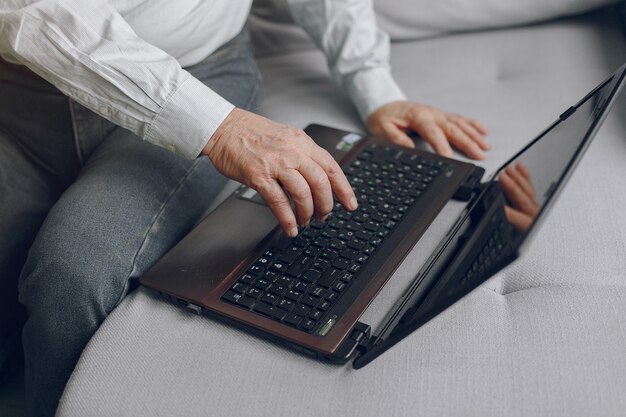 Elegancki Stary Człowiek Siedzi W Domu I Używa Laptopa