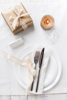 Elegancki wystrój stołu świątecznego z nowoczesnymi dekoracjami sztućców, serwetek, łuków i świąt. bożenarodzeniowy menu pojęcie, zbliżenie, horyzontalny