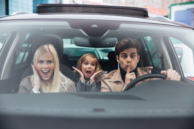 Emocjonalny mężczyzna siedzi w samochodzie z żoną i córką
