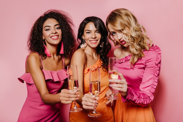 Entuzjastyczne kobiety w sukienkach cieszą się z imprezy