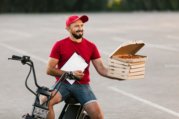 Facet dostawy średni strzał trzyma pudełka z pizzą