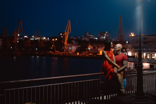 Facet i dziewczyna przytulanie siebie na tle portu w nocy