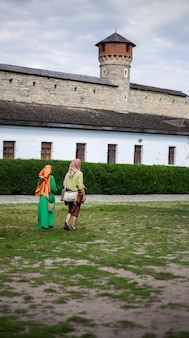 Facet i dziewczyna w średniowiecznych strojach na terenie zamku