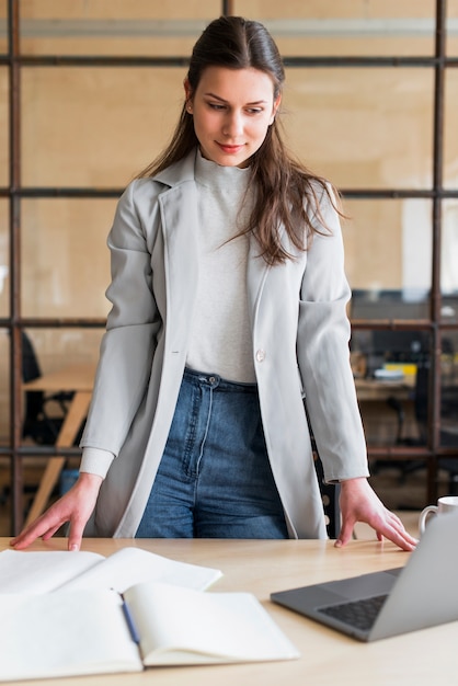 Fachowy atrakcyjny bizneswoman patrzeje laptop w biurze