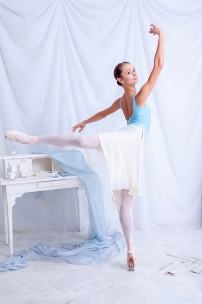 Fachowy baletniczy tancerz pozuje na bielu