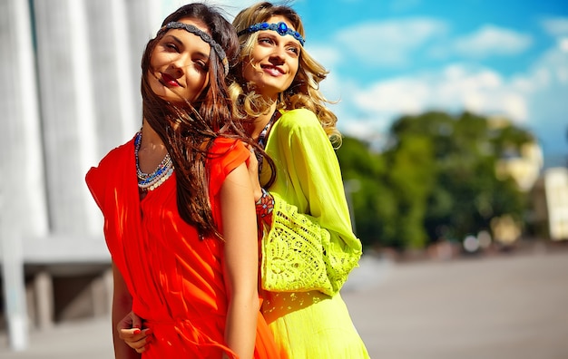 Fasonuje portret dwa młodego hipisa kobiety modeluje w letnim słonecznym dniu w jaskrawym kolorowym modnisiu odziewa
