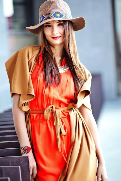 Bezpłatne zdjęcie fasonuje portret młody hipis kobiety model w lato słonecznym dniu w jaskrawym kolorowym modnisiu odziewa w kapeluszu