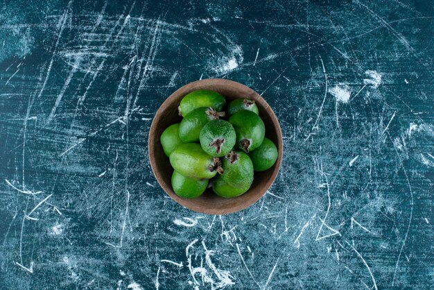 Feijoas w drewnianej filiżance na niebiesko.