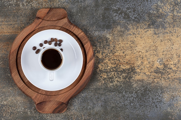 Bezpłatne zdjęcie filiżanka espresso z ziaren kawy na desce.