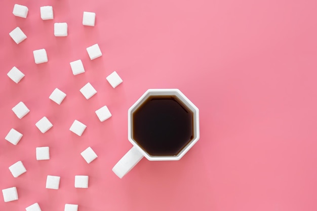 Bezpłatne zdjęcie filiżanka kawy i cukru w kostkach na różowym tle flat lay